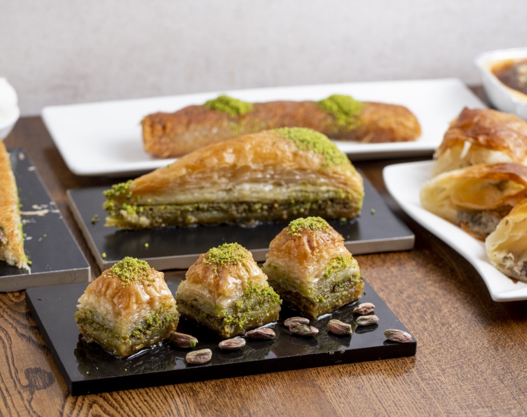 side view of traditional turkish dessert baklava with pistachio on a wooden table