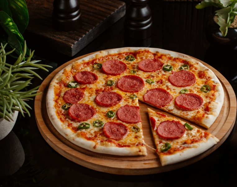 slice-cut-from-classic-pepperoni-pizza-with-green-pepper-rolls